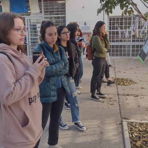 Un grupo de estudiantes participantes del programa recorre la instalación de fotos y carteles sobre el Derecho a la Salud Mental.