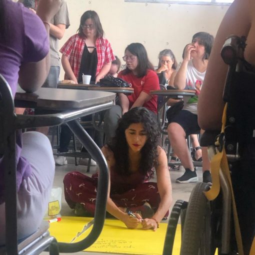 Foto del primer encuentro de Dislocadas en dic. 2023, se ven jóvenes y mujeres conversando en un taller en un aula de la universidad